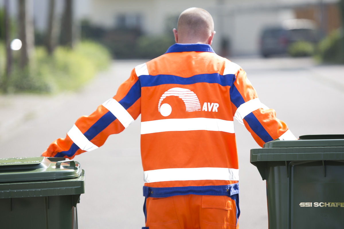 Ein Mitarbeiter der AVR Kommunal bei der Abholung von zwei Tonnen
