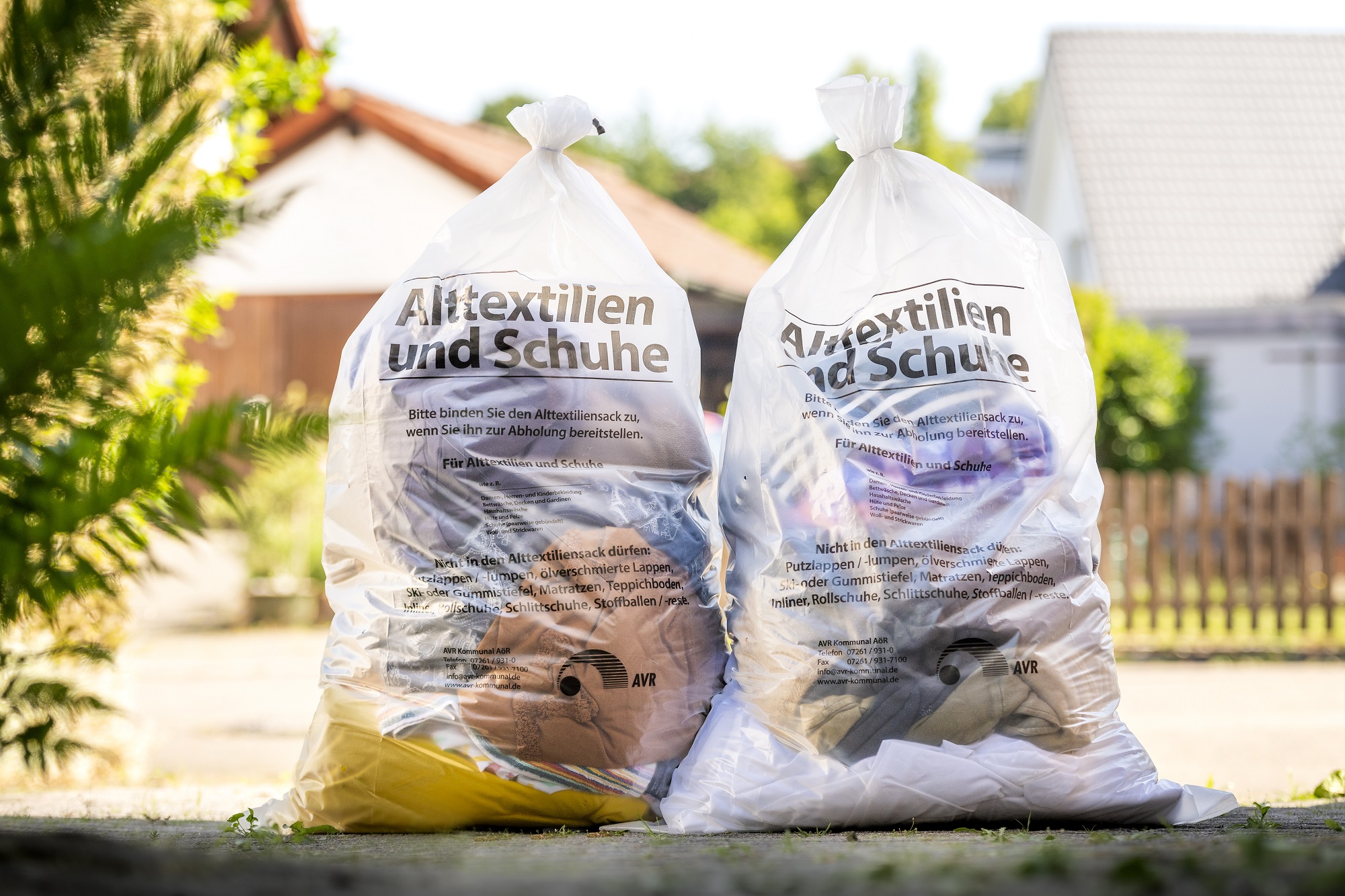 Zwei gefüllte Entsorgungstüten für Alttextilien und Schuhe