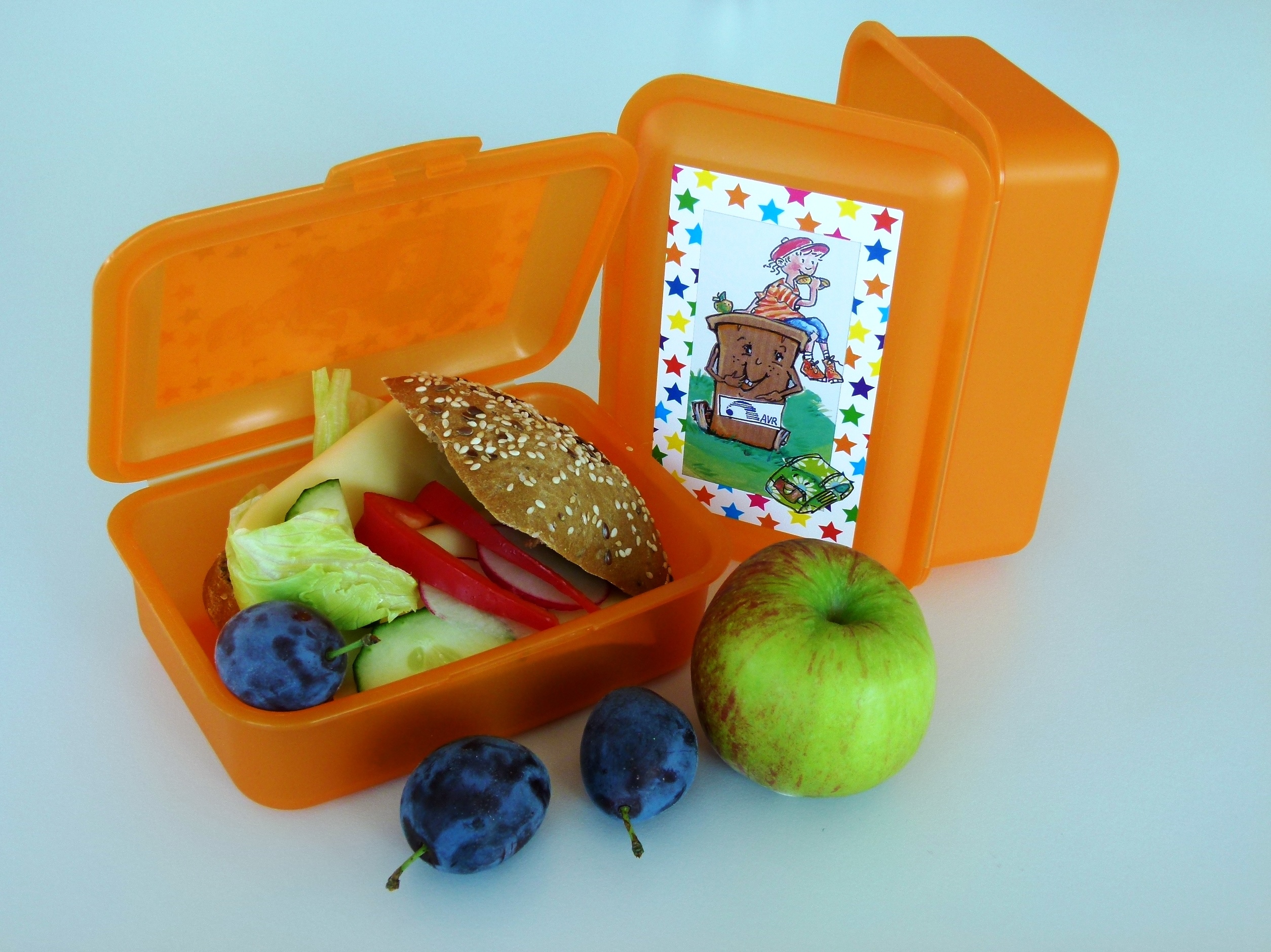 Brotdose der AVR gefüllt mit einem gesunden Pausenbrot und Obst